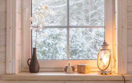 Beautiful burning candles and fairy lights on windowsill indoorsの写真素材