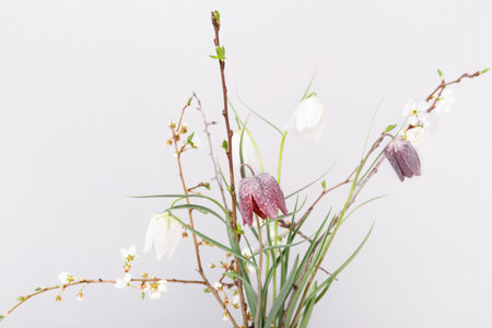 Springtime background with cherry blossom twigs on white desktop, top view, frame, flat lay