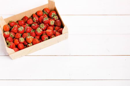 Fresh strawberries in a wooden box on white backgroundの写真素材