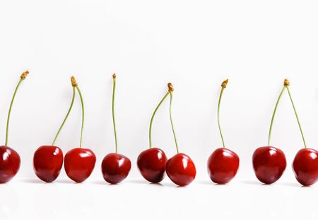 Fresh bright juicy cherries on a white background, minimalistic composition, minimal themeの写真素材