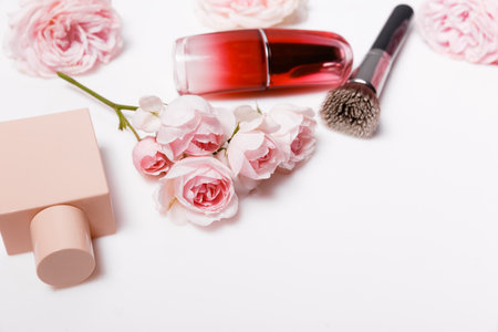 Decorative flat lay composition with makeup products, cosmetics and flowers. Flat lay, top view on pink backgroundの写真素材