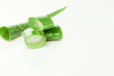 Green fresh aloe vera leaves and slices on white background. Top view. Flat lay.の写真素材