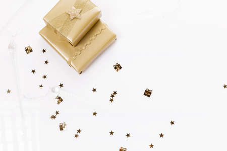 Christmas composition. Golden christmas gift, thuja branches and ribbon. Flat lay, top viewの写真素材