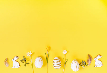 Festive Easter border, frame from easter eggs and spring flower crocus on yellow background. Stylish...
