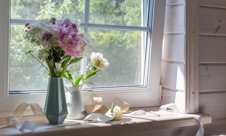 A bouquet of peonies on the windowsill