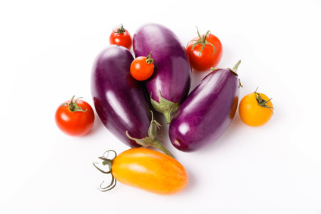Organic tomatoes and eggplant closeup isolated on whiteの写真素材