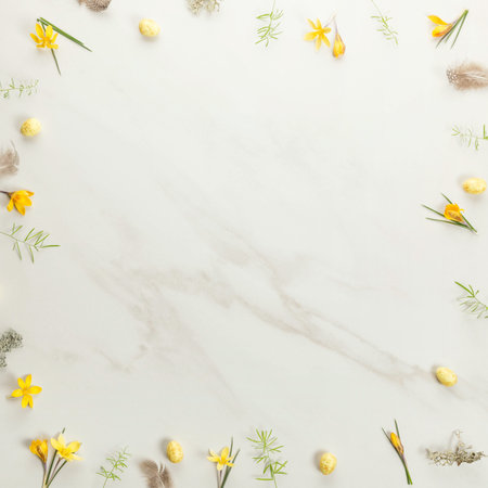 Background frame of spring yellow flowers, Easter eggs on marble background. Minimal Easter conceptの写真素材