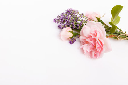 Pink rose and lavender bouquet with craft tag on white background, floral composition with copy space, elegant botanical layout for wedding invitation, birthday greeting, packaging, spa conceptの写真素材