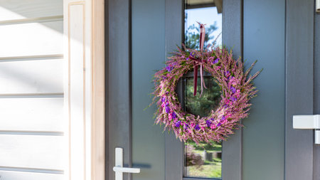 Autumn wreath on front door, festive seasonal decoration with natural flowers, holiday entrance design, concept of cozy home, thanksgiving inspiration, halloween mood, rustic house backgroundの写真素材