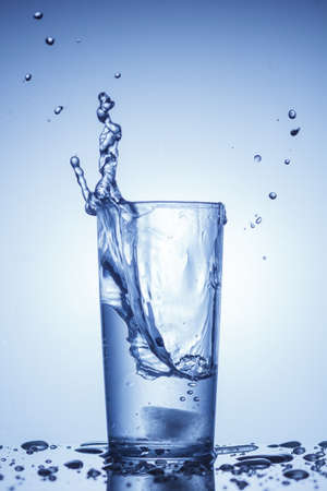 A splash of water in a glass in blueのeditorial素材