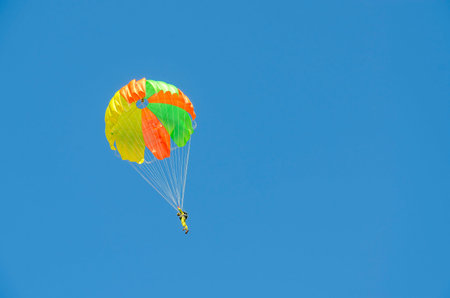 ZYABROVKA, BELARUS - AUGUST 8, 2015: Unknown parachutist performs a jump on the background of a cloudless blue skyのeditorial素材