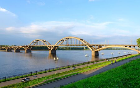 RYBINSK, RUSSIA - JULY 21, 2016: Unidentified people walk along Volga embankment near automobile bridge over Volga River, Rybinsk, Russiaのeditorial素材