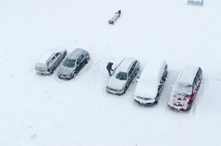 Cyclone "Axel" on territory of Belarus. Top view of cars in yard during heavy snowfallの写真素材