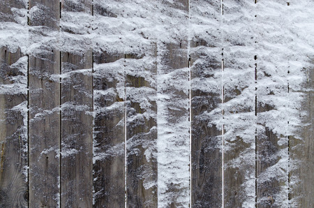 Old wooden fence, covered with snow, backgroundの写真素材