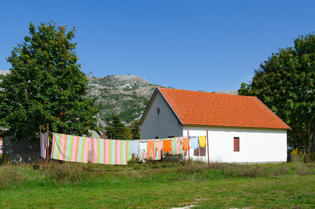 Village of Negushi in mountainous area, Montenegro. Bed linen and clothes is dried on ropes near one-storey village houseの写真素材