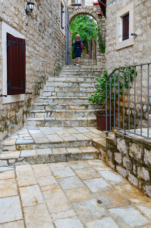 ULCINJ, MONTENEGRO - SEPTEMBER 9, 2017: Unknown tourist woman descends stairs on street in Old Town, Ulcinj, Montenegroのeditorial素材