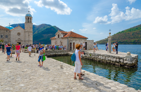 PERAST, MONTENEGRO - SEPTEMBER 10, 2017: Unknown tourists visit Island of Virgin on reef (Gospa od Skrpela Island) in Kotor Bay near city of Perast, Montenegroのeditorial素材