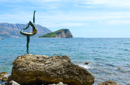 BUDVA, MONTENEGRO - SEPTEMBER 7, 2017: Sculpture "Ballerina" ("Dancer from Budva") against backdrop of Island of Sveti Nikola, Budva, Montenegroのeditorial素材