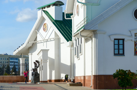 MINSK, BELARUS - OCTOBER 1, 2016: Church of St. Cyril of Turov and Spiritual and Educational Center of Belorussian Orthodox Church. Unknown girl examines monument to John the Theologianのeditorial素材
