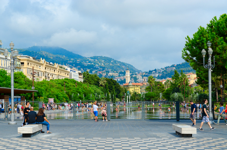 NICE, FRANCE - SEPTEMBER 15, 2018: Unidentified people walk around Place Massena, Promenade du Paillon near fountain (Fontaine Miroir dâeau), Nice, Cote d'Azur, Franceのeditorial素材
