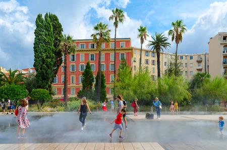 NICE, FRANCE - SEPTEMBER 15, 2018: Unidentified people are in spatter of water of fountain in gardens of Albert I, Nice, Cote d'Azur, Franceのeditorial素材