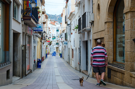 TOSSA DE MAR, SPAIN - SEPTEMBER 12, 2018: Unknown people are on narrow street in historical center of popular resort town of Tossa de Mar, Costa Brava, Catalonia, Spainのeditorial素材