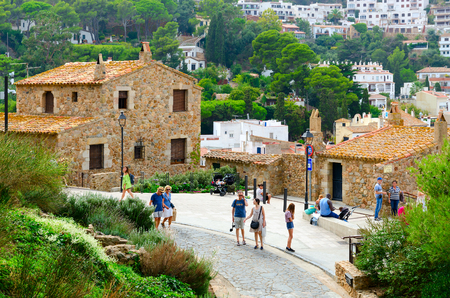 TOSSA DE MAR, SPAIN - SEPTEMBER 12, 2018: Unidentified tourists walk in Old Town, Tossa de Mar, Costa Brava, Spainのeditorial素材