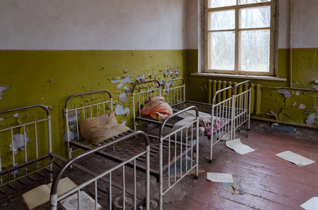 KOPACHI, UKRAINE - NOVEMBER 11, 2018: Bedroom in abandoned kindergarten in destroyed village of Kopachi, 10 km exclusion zone of Chernobyl nuclear power plant, Ukraineのeditorial素材