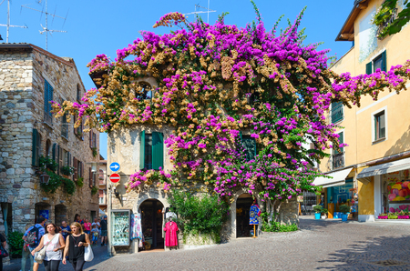 SIRMIONE, ITALY - SEPTEMBER 16, 2018: Unknown tourists walk in historic center of resort town of Sirmione, Italyのeditorial素材