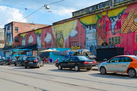 MINSK, BELARUS - AUGUST 12, 2019: Street art on Oktyabrskaya street. Graffiti on wall of industrial building, created as part of Vulica Brasil festival (author Eugene Cowek Matyuto). Unknown people are on streetのeditorial素材