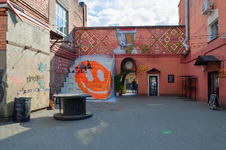 MINSK, BELARUS - AUGUST 12, 2019: Unidentified people relax on open air near popular cafe "Lavka" on Oktyabrskaya street. Graffiti on wall of building, created as part of Vulica Brasil festivalのeditorial素材