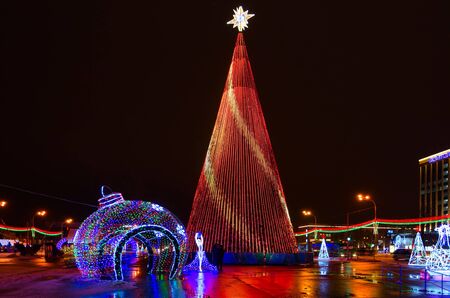 GOMEL, BELARUS - JANUARY 8, 2019: Unknown people are near New Year fir tree on Lenin Square, night view, Gomel, Belarus. Festive illuminationのeditorial素材