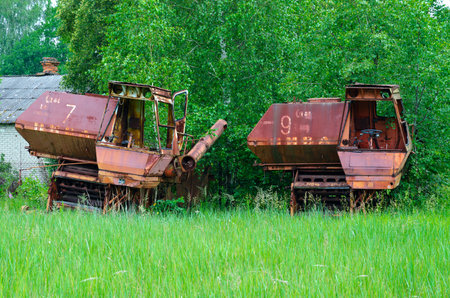 Abandoned combine harvesters at former farm yard of state farm "Victory of socialism" in resettled village of Pogonnoye in Chernobyl exclusion zone, Belarusのeditorial素材