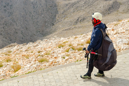 MOUNT TAHTALI, TURKEY - SEPTEMBER 21, 2022: Unknown paragliding instructor goes to place of descent from top of Mount Tahtali in vicinity of Kemer, Turkeyのeditorial素材