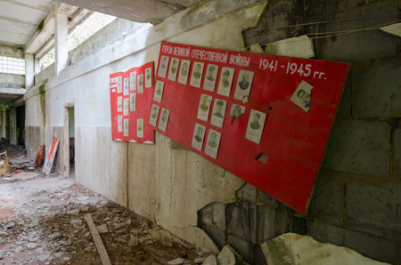 POGONNOE, BELARUS - JULY 4, 2020: Corridor of abandoned school in resettled village of Pogonnoye in exclusion zone of Chernobyl nuclear power plant, Gomel region. Text: "Heroes of Great Patriotic War 1941-1945"のeditorial素材