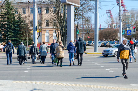 GOMEL, BELARUS - MARCH 26, 2020: Unknown people cross street at pedestrian crossing. Absence of quarantine in country during WHO pandemicのeditorial素材