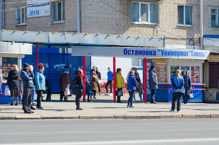 GOMEL, BELARUS - MARCH 26, 2020: Unknown people stand at public transport stop during pandemic declared by WHO, Gomel, Belarusのeditorial素材