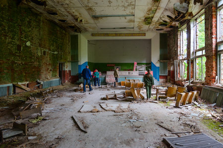 POGONNOYE, BELARUS - JULY 4, 2020: Tourist group is in abandoned building of former House of Culture in resettled village of Pogonnoye in Chernobyl Nuclear Power Plant exclusion zone, Belarusのeditorial素材