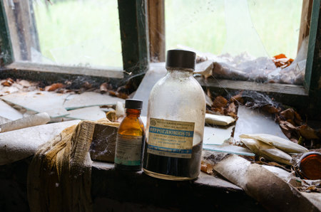POGONNOYE, BELARUS - JULY 4, 2020: Dirty glass bottles of medicines in former veterinary laboratory in resettled village of Pogonnoye in exclusion zone of Chernobyl nuclear power plant, Belarusのeditorial素材