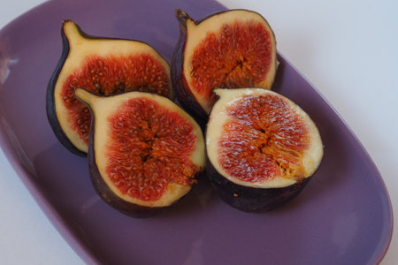 Purple figs cut on a beautiful dish.の写真素材