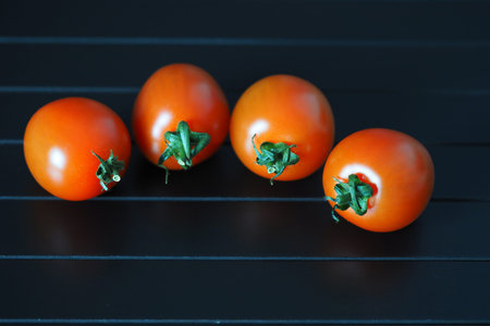 Red ripe cherry tomatoes on a black background.の写真素材