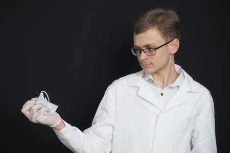 Portrait of a young doctor of European appearance in a white medical gown. Medical student. High quality photoの写真素材