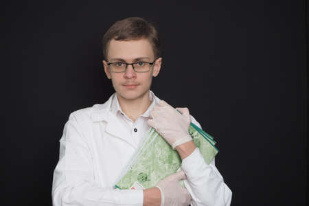 Portrait of a young doctor of European appearance in a white medical gown. Medical student. High quality photoの写真素材