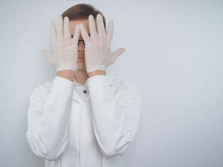 Portrait of a young man of European appearance in a white medical coat. A young doctor in a white coat. Medical student. . High quality photoの写真素材
