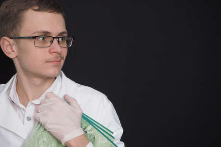 Portrait of a young doctor of European appearance in a white medical gown. Medical student. High quality photoの写真素材