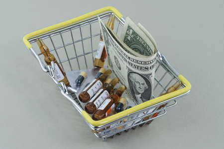 Business and medicine. Buying and selling medicines. Drugs, pills, vials with solutions and dollars in the basket. High quality photoの写真素材