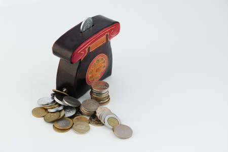 A money box with coins is isolated on a white background with a place for an inscription. High quality photoの写真素材