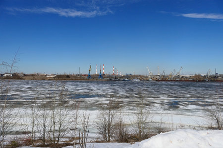 Spring ice on the river. Plant by the river and sand mining. High quality photoの写真素材