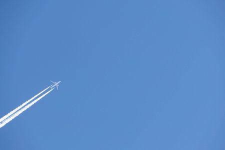 A jet plane in the sky. a double track from a jet plane in a blue sky. High quality photo