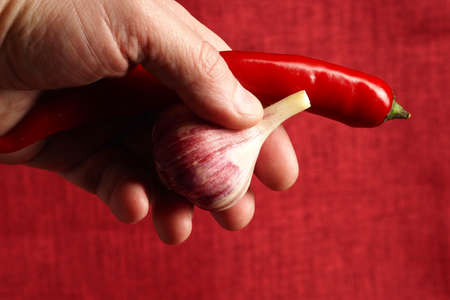 A man holds vegetables, red peppers and fresh garlic. High quality photoの写真素材